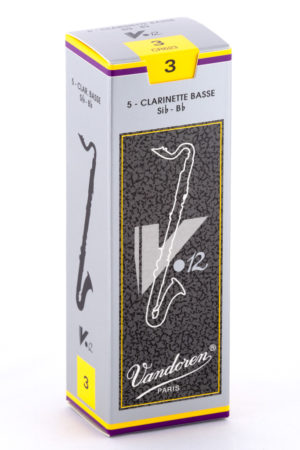 Eine kleine, längliche, graue Pappschachtel mit gelben und violetten Akzenten zeigt eine stilisierte, schwarze Bassklarinette-Abbildung und den Schriftzug "Vandoren Paris".