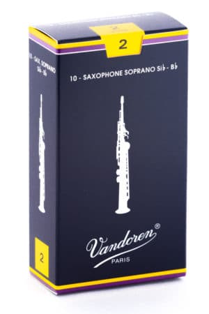 Eine längliche, dunkelblaue Pappschachtel mit gelben und lilafarbenen Akzenten, die 10 Saxophonblätter für Sopran-Saxophone in der Stärke 2 enthält,zeigt eine stilisierte Abbildung eines Saxophons und den Schriftzug Vandoren Paris.