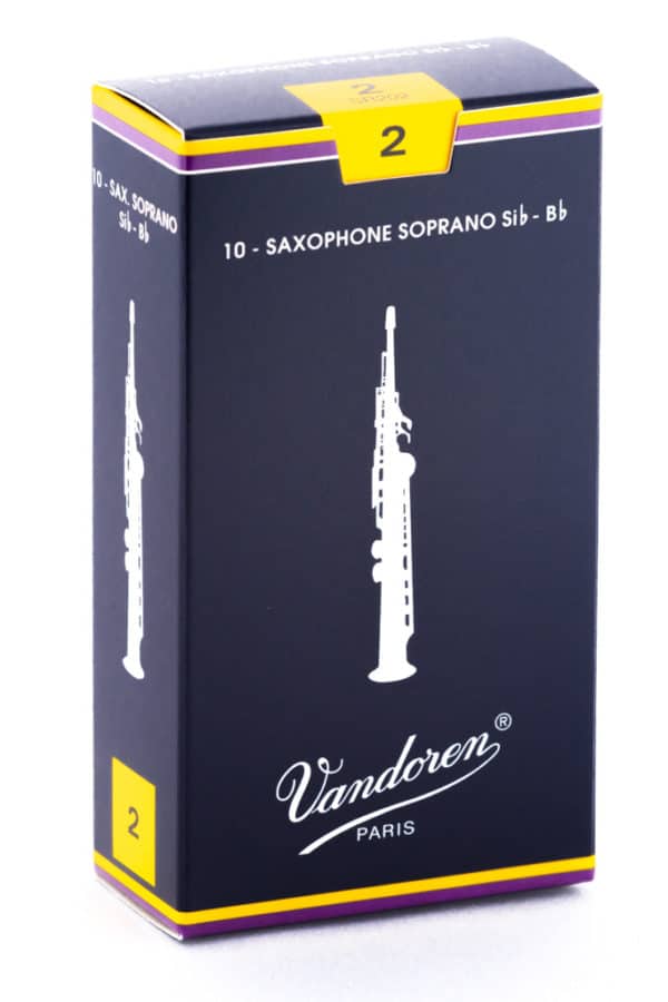 Eine längliche, dunkelblaue Pappschachtel mit gelben und lilafarbenen Akzenten, die 10 Saxophonblätter für Sopran-Saxophone in der Stärke 2 enthält,zeigt eine stilisierte Abbildung eines Saxophons und den Schriftzug Vandoren Paris.