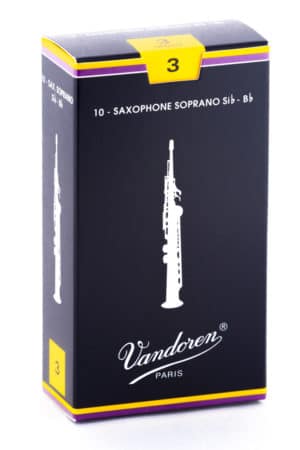 Eine schwarze Kartonverpackung mit gelbem und violettem Rand, auf der eine weiße Abbildung eines Sopransaxophons und der Schriftzug "Vandoren PARIS" abgebildet sind, während die Ziffer "3" in einem gelben Quadrat auf der Oberseite zu sehen ist.