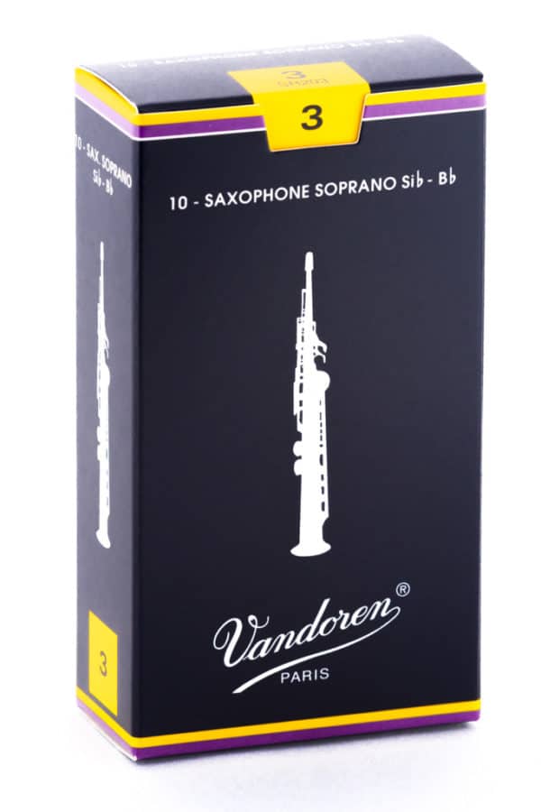 Eine schwarze Kartonverpackung mit gelbem und violettem Rand, auf der eine weiße Abbildung eines Sopransaxophons und der Schriftzug "Vandoren PARIS" abgebildet sind, während die Ziffer "3" in einem gelben Quadrat auf der Oberseite zu sehen ist.
