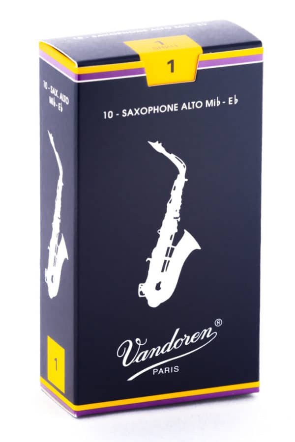 Eine dunkelblaue Kartonverpackung mit gelbem Aufkleber und lila-gelbem Rand zeigt eine schematische Darstellung eines Saxophons sowie den Schriftzug Vandoren Paris.