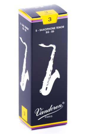 Eine hochkant stehende dunkelblaue Pappschachtel für Saxophonblätter mit gelben Akzenten und dem weißen Aufdruck einer stilisierten Saxophongrafik sowie dem Markennamen "Vandoren Paris".