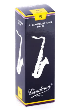 Eine hochformatige, dunkelblau und gelb gefärbte Pappschachtel der Marke Vandoren mit der Aufschrift "5 - SAXOPHONE TENOR" und einer weißen Saxophon-Illustration ist vor einem weißen Hintergrund abgebildet.