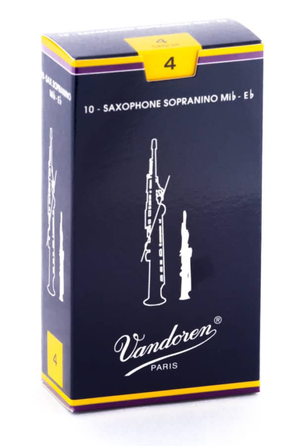 Eine dunkelblaue Kartonschachtel mit gelben Akzenten und einer weißen Abbildung von zwei Saxophonblättern trägt den Aufdruck "Vandoren Paris" und die Bezeichnung "10 - SAXOPHONE SOPRANINO Mib - Eb".