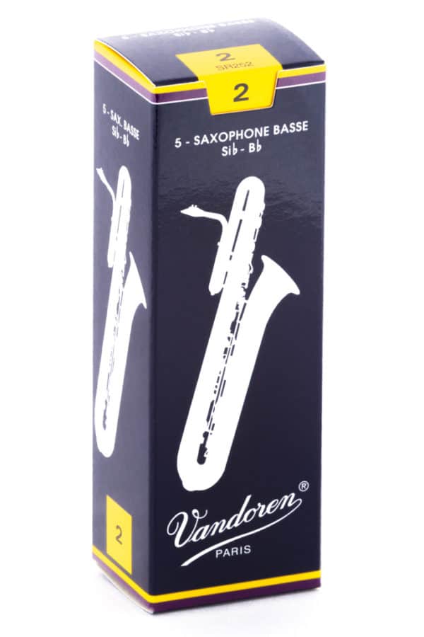 Eine dunkelblaue Pappschachtel mit gelben Akzenten, die eine stilisierte, weiße Abbildung eines Baritonsaxophons und den Schriftzug "Vandoren Paris" zeigt, steht auf einem weißen Untergrund.
