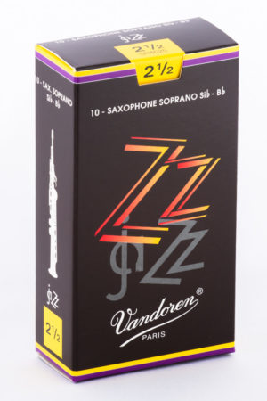 Eine aufrecht stehende, rechteckige, schwarze Pappschachtel mit gelben und violetten Akzenten, auf der Vorderseite der Schriftzug "ZZ jazz" in rot-orangen und grauen Großbuchstaben, darunter "Vandoren PARIS", und auf der Seite eine Abbildung eines Sopransaxophons abgebildet ist.