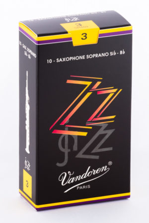 Eine schwarze Schachtel mit gelben und lilafarbenen Akzenten trägt die Aufschrift "ZZ Jazz" in verzerrten, roten und gelben Buchstaben, darunter "Vandoren Paris" und die Angabe "10 - Saxophone Soprano si♭-Bb".
