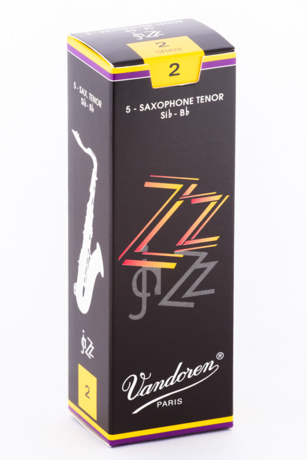 Ein länglicher, schwarzer Karton mit dem Aufdruck "Vandoren Paris ZZ" in Gelb- und Rottönen, der für Tenorsaxophonblätter der Stärke 2 wirbt und dessen obere und untere Kanten durch dünne, gelbe und lilafarbene Streifen geziert sind, steht auf einem weißen Hintergrund.