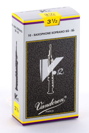 Eine hochformatige, rechteckige, größtenteils weiße Pappschachtel mit gelben und violetten Akzenten zeigt die Aufschrift "10 - SAXOPHONE SOPRANO Sib - Bb" und eine stilisierte Abbildung eines Sopransaxophons mit dem Vandoren-Logo.