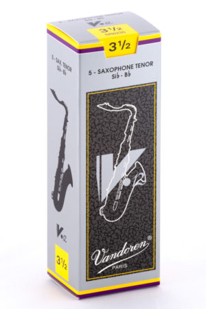 Eine schmale, hochformatige, grau-weiß-gelb-violette Pappschachtel mit der Aufschrift "Vandoren Paris" und der Bezeichnung "5 Saxophone Tenor Sib - Bb" zeigt ein stilisiertes Saxophon und trägt die Größenangabe "3 1/2".