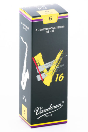 Eine längliche, dunkelgrüne Pappschachtel für Saxophonblätter steht auf einer weißen Oberfläche und zeigt auf der Vorderseite ein gelbes, kalligraphisches "V16"-Logo mit roten und grauen Akzenten, sowie den Schriftzug "Vandoren Paris".