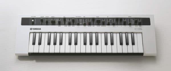 Das Bild zeigt einen weißen Yamaha Reface CS Synthesizer mit schwarzen und weißen Tasten sowie schwarzen Reglern.