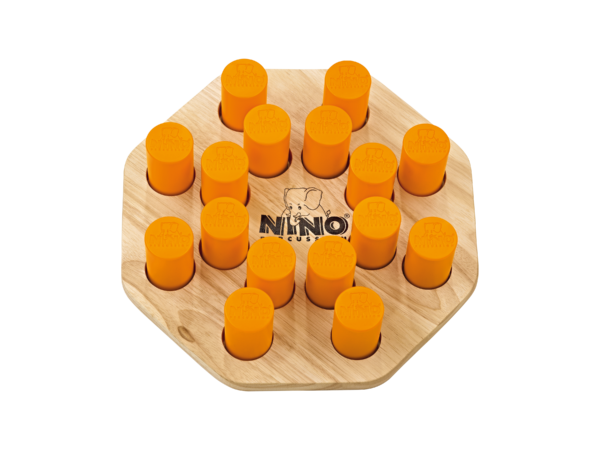 Das Bild zeigt einen Nino Shake'n Play 526, ein hölzernes, sechseckiges Musikinstrument mit 16 orangefarbenen Stiften.