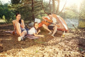 Geänderte Öffnungszeiten im Sommer arty, camping of men and women group at forest. They relaxing, singing a song against green grass. The vacation, summer, adventure, lifestyle, picnic concept Banner