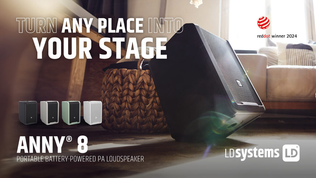 Ein schwarzer LD Systems ANNY® 8 Lautsprecher steht auf einem Holzboden vor einem geflochtenen Korb, flankiert von einer Reihe kleinerer, gleichfarbiger Lautsprechersymbole und dem Schriftzug "TURN ANY PLACE INTO YOUR STAGE".