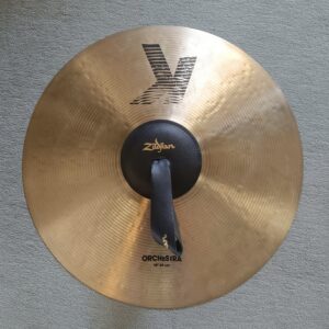 Das Bild zeigt ein gold glänzendes X-ORCH-Extra-Dry-Becken der Marke Zildjan auf grauem Grund, das von oben fotografiert wurde.