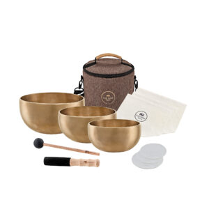 Das Bild zeigt ein Meinl Sonic Energy Yoga Nidra Singing Bowl Set, bestehend aus drei bronzefarbenen Klangschalen unterschiedlicher Größe, zwei Schlägeln, einer Tragetasche mit braunem Stoff und Griff, sowie weißen Filzuntersetzern und einer weißen Stofftasche.