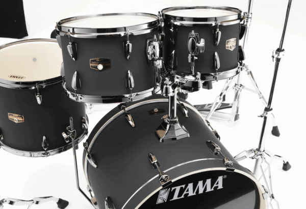 Ein schwarzes Tama Imperialstar IP50H6WBN-BOB Schlagzeug mit silberfarbenen Metallelementen steht vor einem weißen Hintergrund.