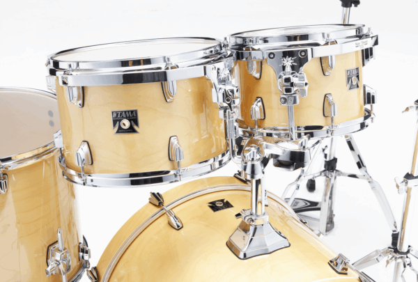 Nahaufnahme eines Tama Superstar Classic CL50R-GNL Schlagzeugs mit hellen, holzfarbenen Kesseln und glänzendem Chrom-Hardware.