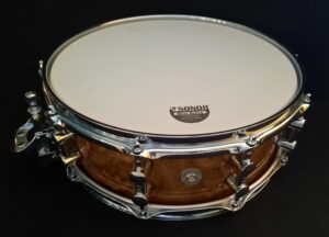 Nahaufnahme einer Sonor 14"x06" ProLite Snare Drum in Chocolate Burl Ausführung, ein Ausstellungsstück mit hellem Schlagzeugfell und glänzenden Chrombeschlägen.