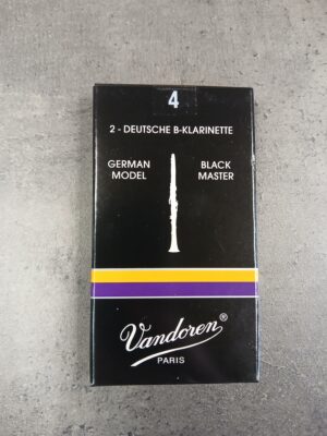 Abgebildet ist eine schwarze Schachtel Vandoren Stärke 4 Black Master German Model Blätter für deutsche B-Klarinette, verziert mit einem lila-goldenen Streifen und einer Abbildung einer Klarinette.