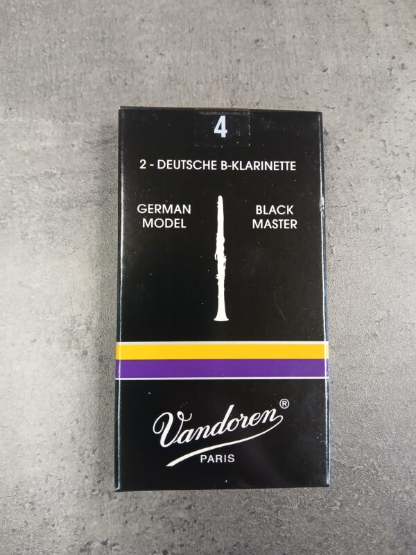 Abgebildet ist eine schwarze Schachtel Vandoren Stärke 4 Black Master German Model Blätter für deutsche B-Klarinette, verziert mit einem lila-goldenen Streifen und einer Abbildung einer Klarinette.