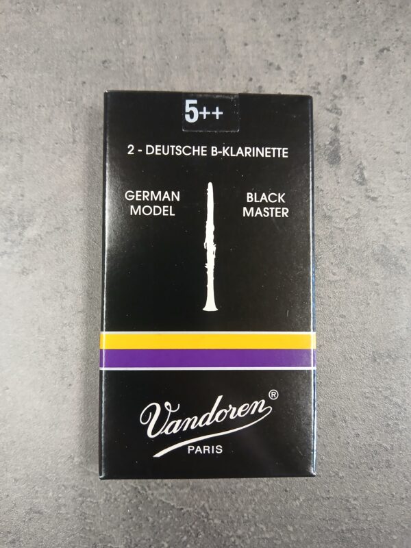 Eine schwarze Verpackung für "Vandoren Stärke 5++ Black Master German Model Blätter CR187TP" für die deutsche B-Klarinette mit einem stilisierten, weißen Klarinettenbild und einem violetten Streifen in der Mitte.