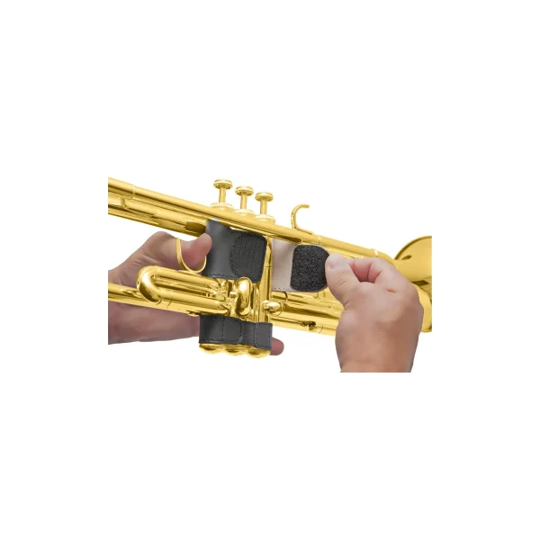 Zwei Hände befestigen schwarzen BG PTV Lederschutz an den Ventilgehäusen einer goldenen Trompete.