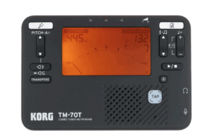 Nahaufnahme eines schwarzen Korg TM-70T Metronom- und Stimmgeräts mit orangefarbenem Display und Bedienelementen an der Ober- und rechten Seite.