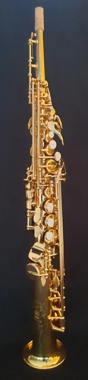 Das Bild zeigt ein gebrauchtes, goldenes Yamaha YSS-475 Sopransaxophon auf einem dunklen Hintergrund.