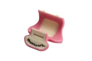 Ein pink-weisser Thumbport für Querflöte liegt auf einem weißen Hintergrund und zeigt eine violette, U-förmige Halterung mit einer weissen Innenfläche sowie ein abstehendes, weisses Element mit violettem Rand und einer kleinen Kerbe.