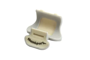 Ein graues Thumbport für Querflöten, bestehend aus einer U-förmigen Halterung mit einer beigen Auflagefläche und einer grauen Daumenstütze mit dem Aufdruck "thumbport".