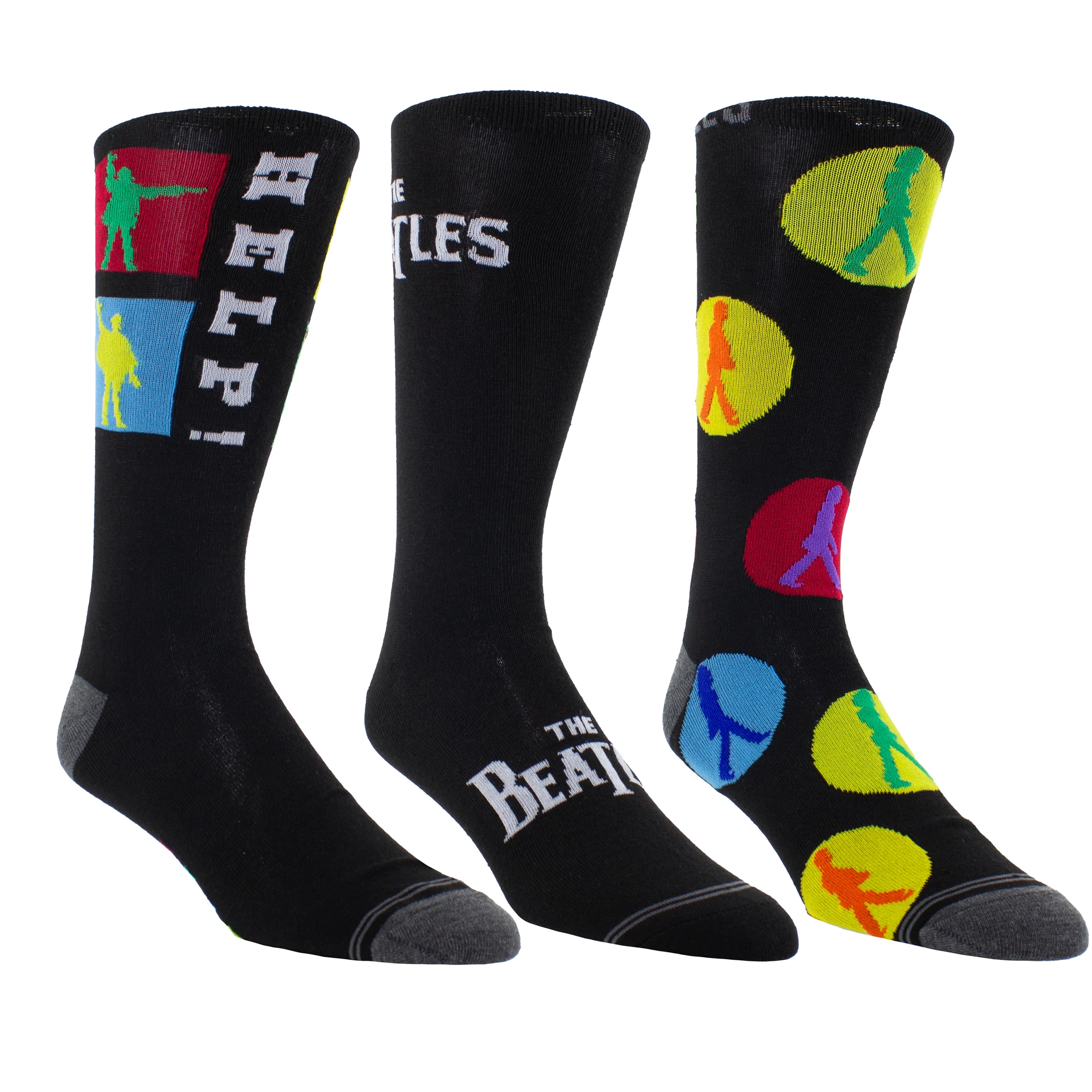 Drei schwarze Socken mit Beatles-Motiven, darunter farbige Silhouetten, der Schriftzug "The Beatles" und Friedenstauben in bunten Kreisen, liegen nebeneinander.