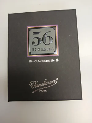 Die dunkelgraue Schachtel für Vandoren B-Klarinetten Rue Lepic in Stärke 4.5 trägt ein silbernes, lilagelumrahmtes Quadrat mit der schwarzen Aufschrift "56 RUE LEPIC" sowie den silbernen Schriftzug "10 CLARINETTE Sib-Bb" und "Vandoren PARIS".