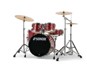 Ein rotes Sonor AQX Studio Set Red Moon Sparkle Schlagzeug ist vor einem neutralen Hintergrund aufgebaut, bestehend aus einer Bassdrum mit Sonor-Logo, mehreren Toms und Becken auf Stativen.