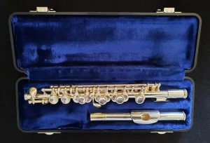 Eine Gemeinhardt Piccolo 4SH liegt in einem schwarzen Koffer mit blauem Samtbezug.