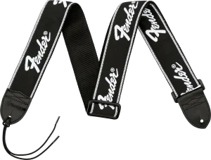 Nahaufnahme eines schwarzen Gitarrengurtes mit dem weißen Fender-Logo, der an beiden Enden schwarze Lederenden mit Schnüren zur Befestigung aufweist und vor einem schwarzen Hintergrund liegt.