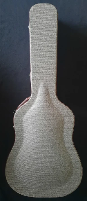 Der hellbeige Guild GAD 40 CE Gitarrenkoffer liegt vertikal auf dunklem Grund.