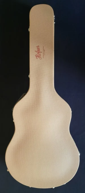 Das Bild zeigt einen beigen Höfner HVSP-SB Gitarrenkoffer in Draufsicht, auf dem der Markenname "Höfner" in roter Schrift aufgedruckt ist.