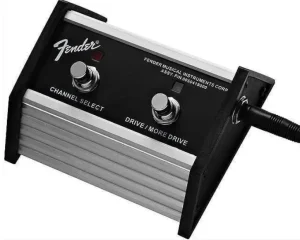 Ein silberner Fender Fußschalter mit schwarzem Bedienfeld, beschriftet mit "Channel Select" und "Drive/More Drive", verfügt über zwei verchromte Fußtaster und ein angeschlossenes schwarzes Kabel.