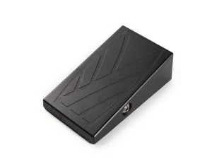 Das Bild zeigt eine schwarze "SX Stomp Box Serie III" mit abgeschrägter Bauform und einem eingefrästen Pfeilmuster auf der Oberfläche.